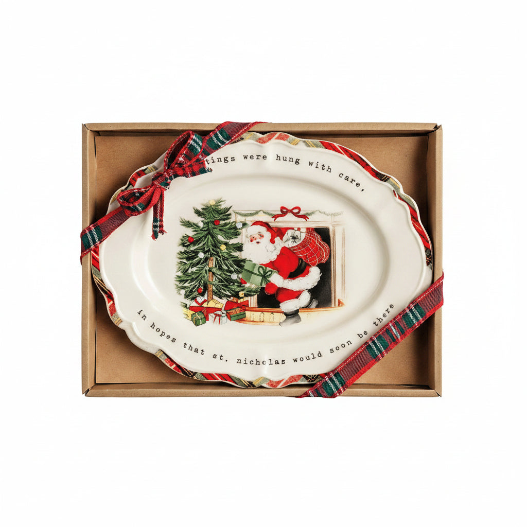 plate with design of santa coming out of a fireplace next to a tree shown in a box with tartan ribbon on it