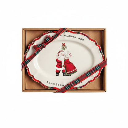 plate with design of mr and mrs claus coming standing under mistle toe shown in a box with tartan ribbon on it