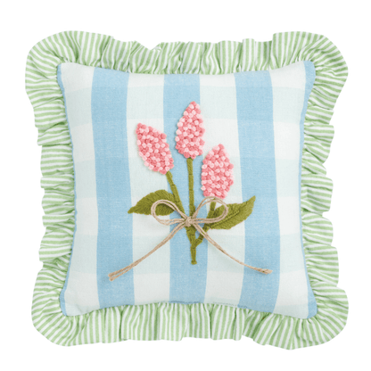 blue and white striped pillow with green striped ruffled edge, and pink embroidered flowers