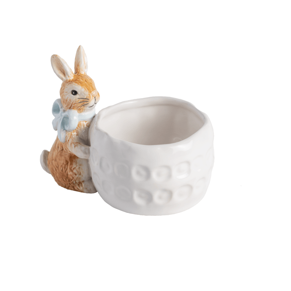 white ceramic bowl with brown ceramic bunny wearing blue bow around its neck attached to the the side of bowl
