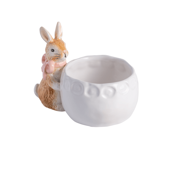 white ceramic bowl with brown ceramic bunny wearing pink bow around its neck attached to the the side of bowl