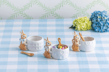 3 buny bowls  on a blue gingham cloth, one has candies in it