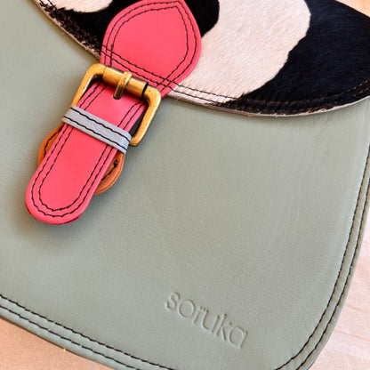 close-up of front pink buckle of mint quinn bag.