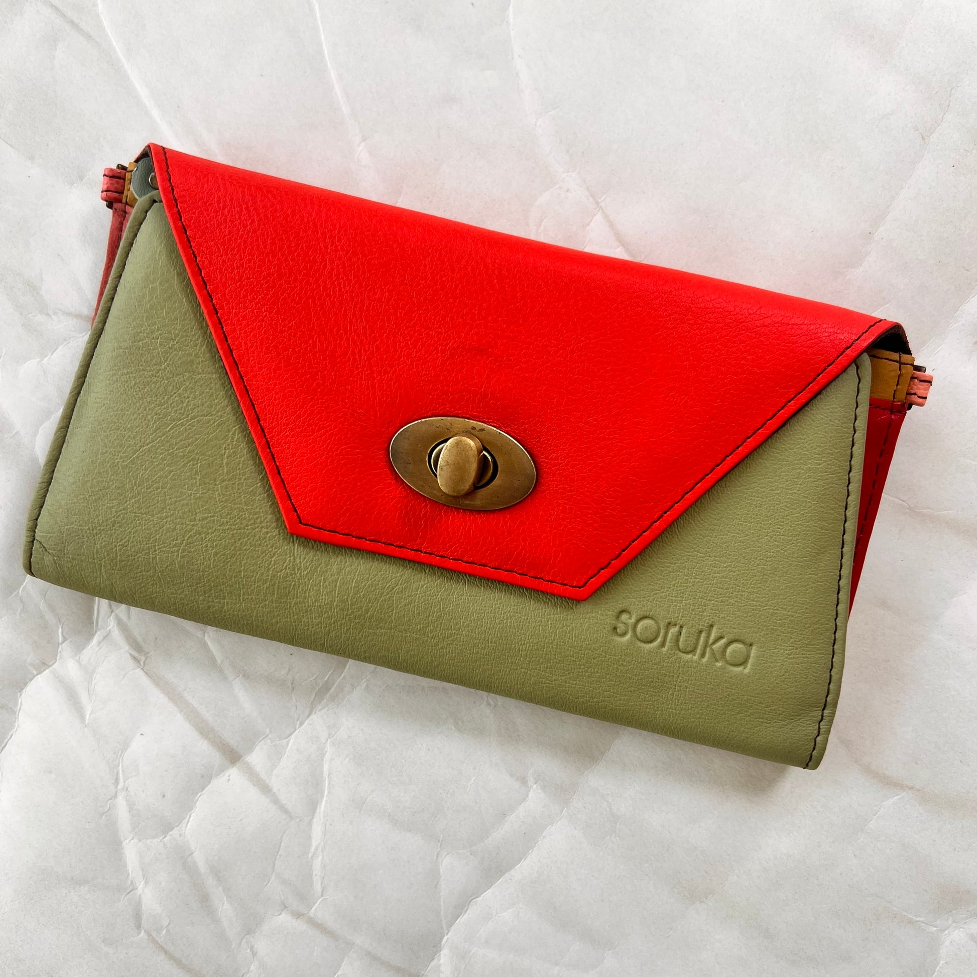 green secret clutch wallet with orange flap.