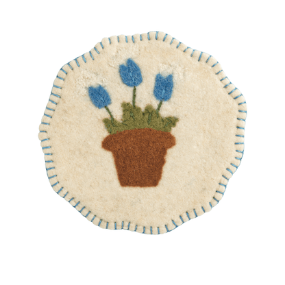white Felted Floral Trivet with design of blue flowers in a garden pot and blue stitched trim