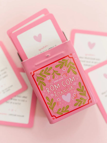 rom com trivia tin and cards on a pink background
