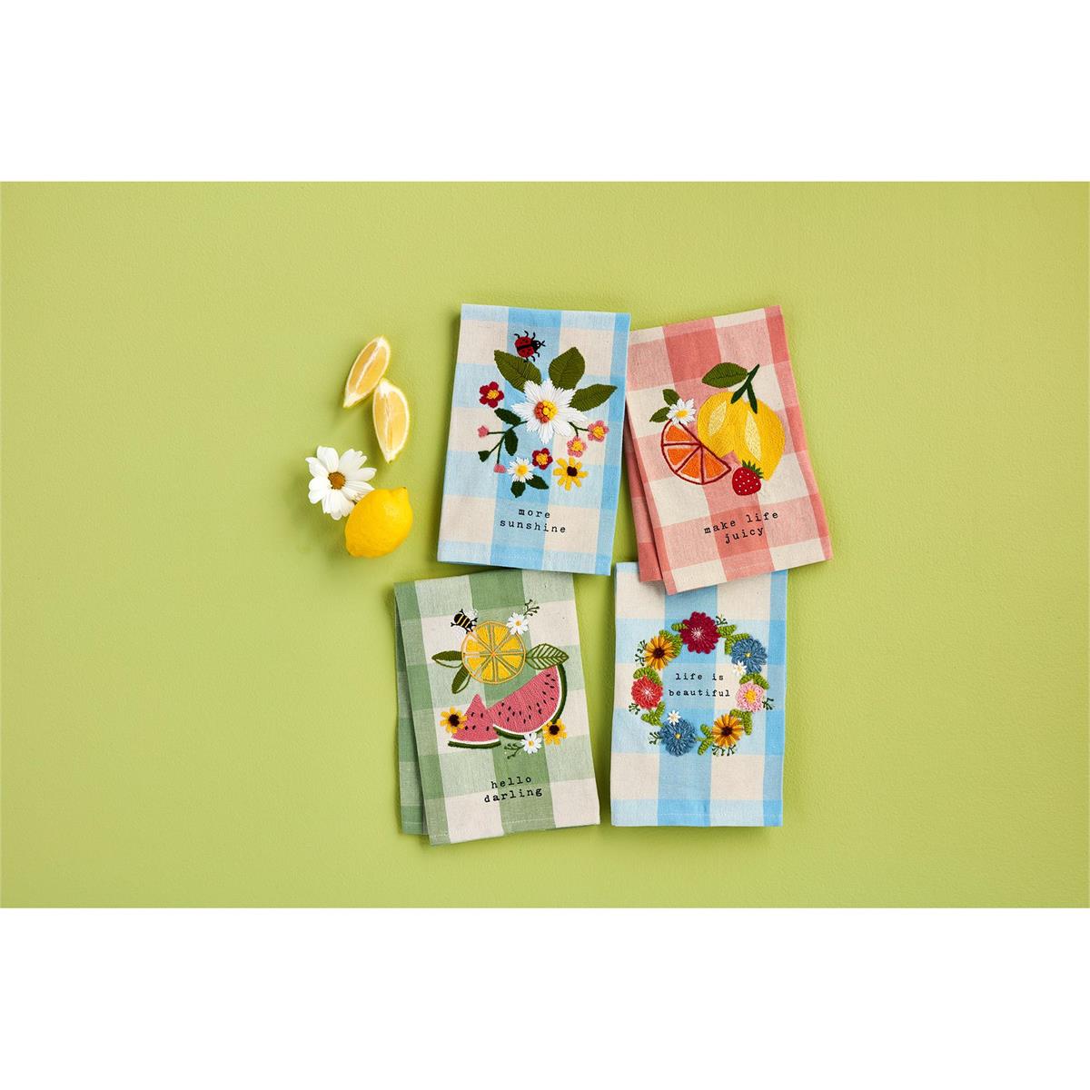 4 styles of fruity floral hand towels arranged on a light green background with lemons and a daisy.