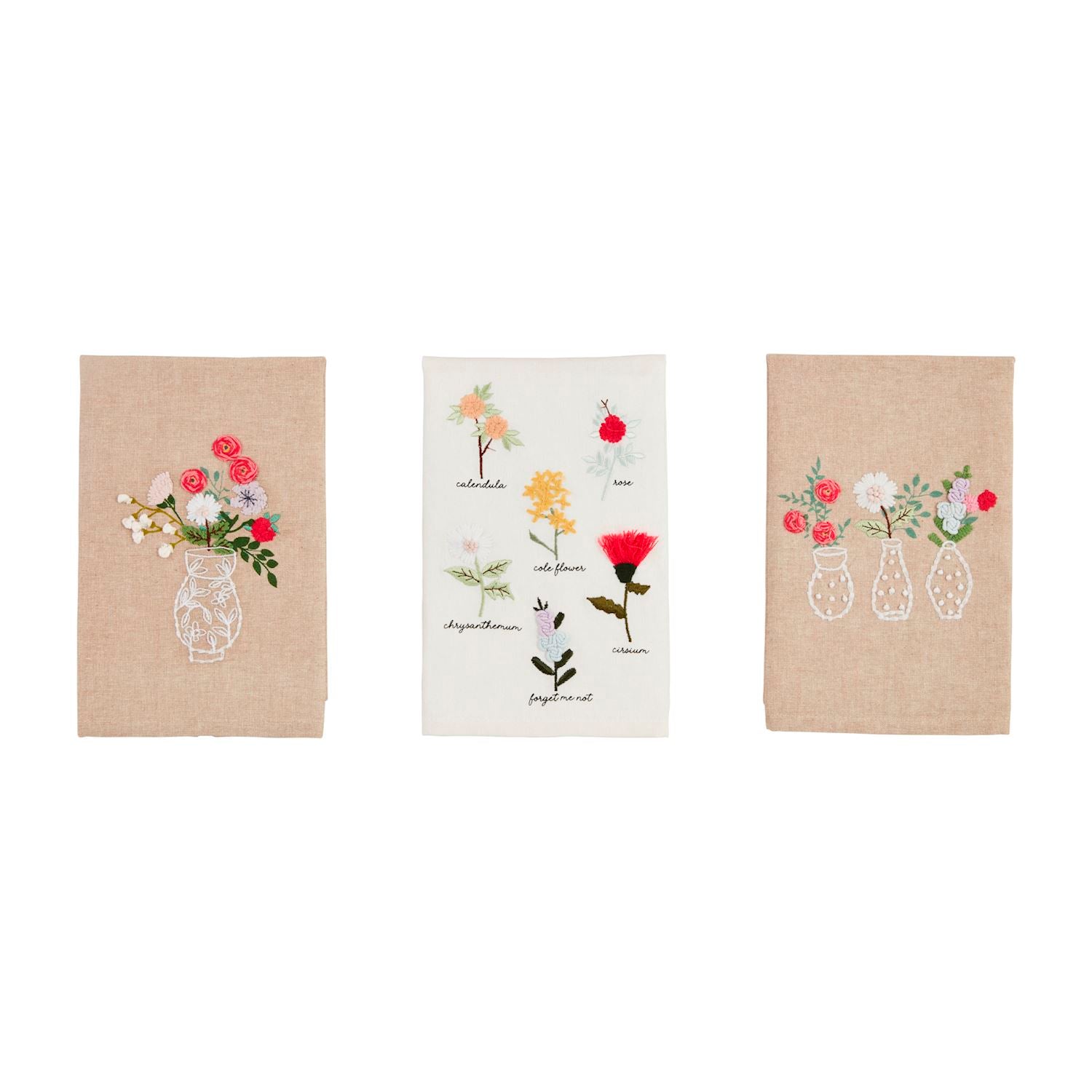 Three embroidered towels with floral designs on a white background