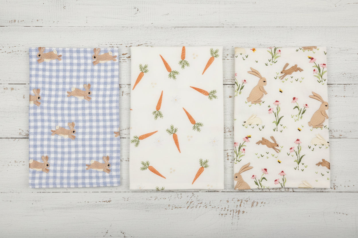 3 styles of easter hand towels in a row on a white wood background