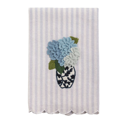 Striped tea towel with a floral design in the center and scalloped hem