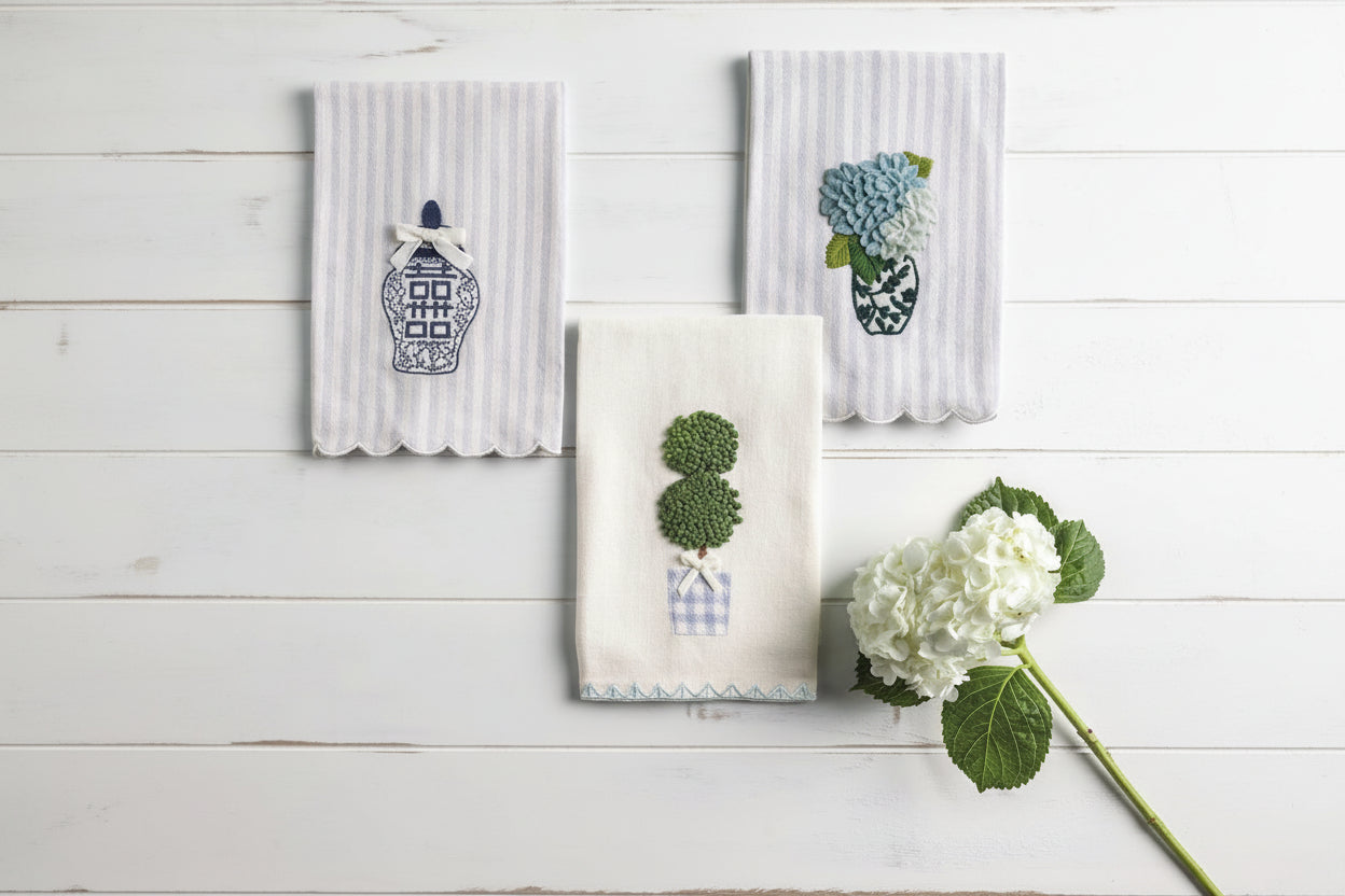 3 blue and white tea towels with stitched designs on them