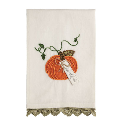 Decorative towel with embroidered pumpkin and leaf design on a white background