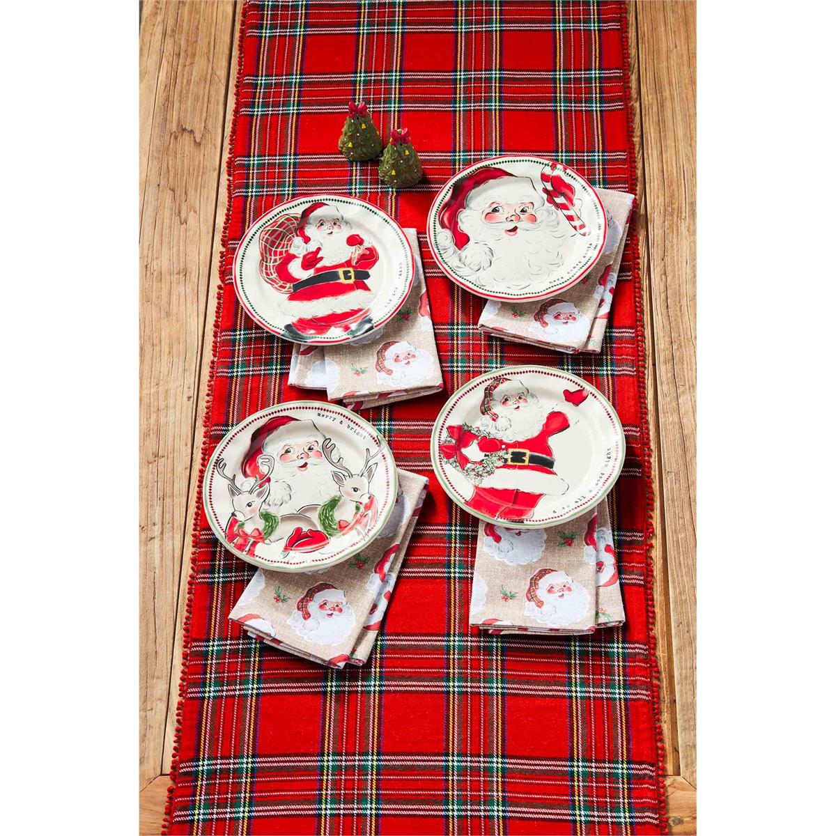 all four patterns of vintage santa salad plates displayed on a rustic wooden table with a tartan table runner with christmas towels