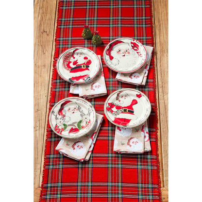 all four patterns of vintage santa salad plates displayed on a rustic wooden table with a tartan table runner with christmas towels