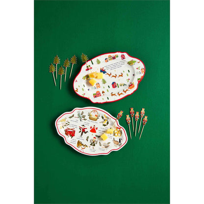 both styles of christmas plate and toothpick sets displayed on a green surface