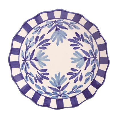 Decorative plate with blue leaf pattern and striped rim on a white background