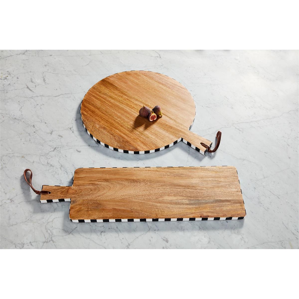 2 styles of mango wood boards with black and white check rims set on a granite countertop, one board has figs on it.