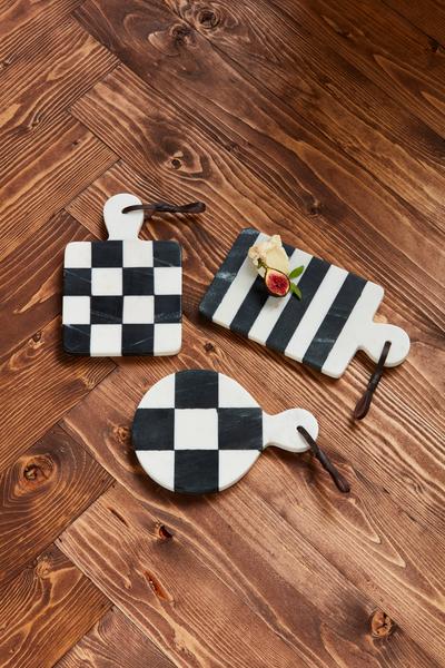 Assorted many marble black and white boards arranged on a wooden surface.