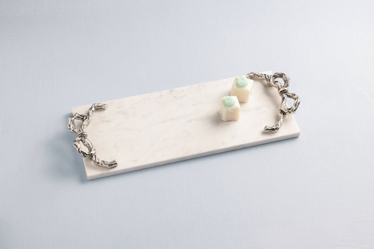 bow marble board  with a couple of treats on it shown on a pale blue background