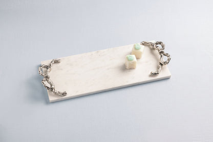 bow marble board  with a couple of treats on it shown on a pale blue background