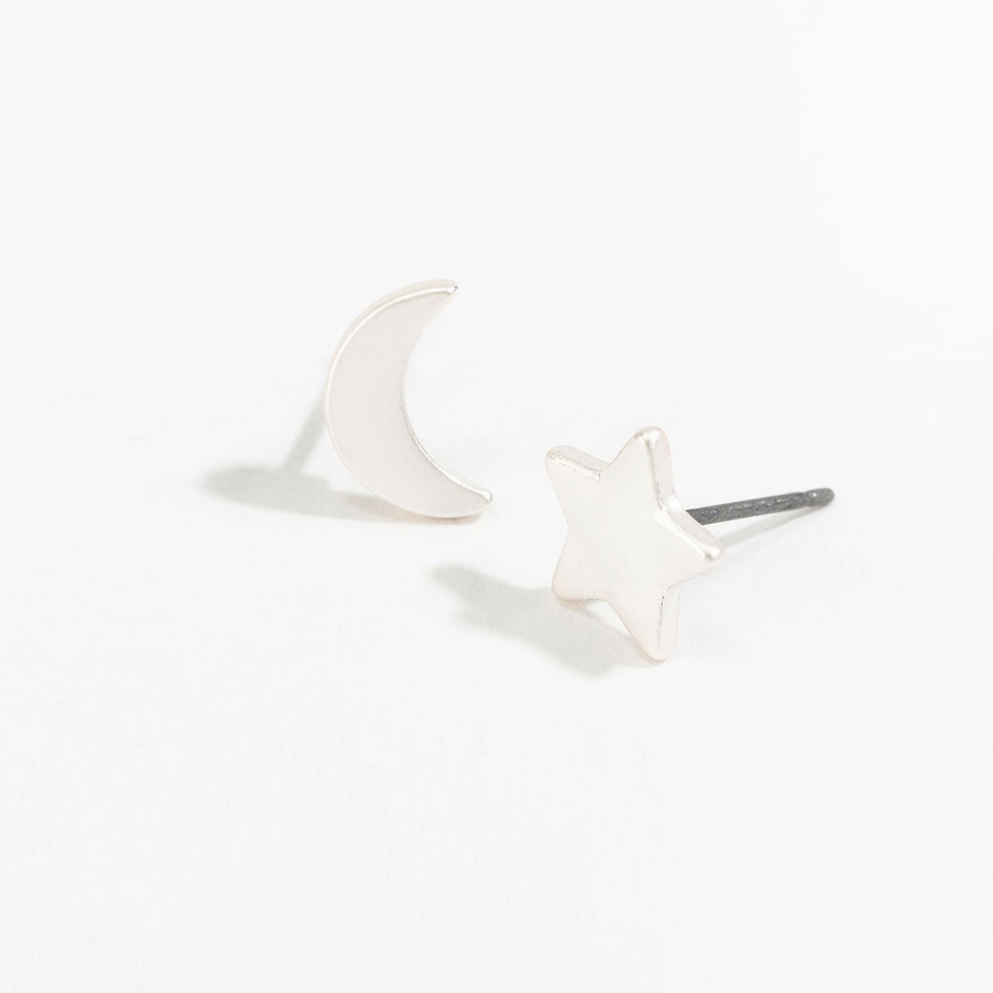 silver star and moon stud earrings on a white background