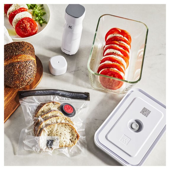 photo of bag and glass container with food and cutting board on counter top