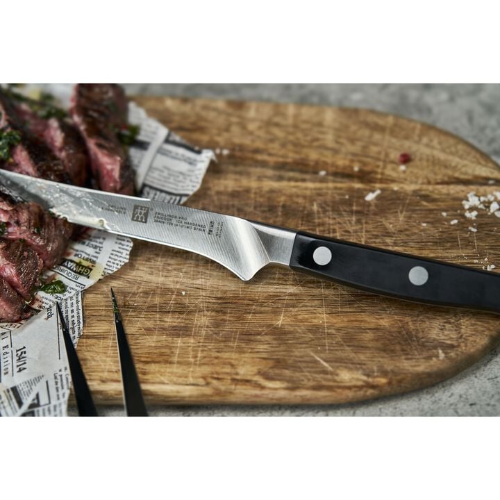 close-up of PRO Steak Knife on a cutting board with a piece of meat.