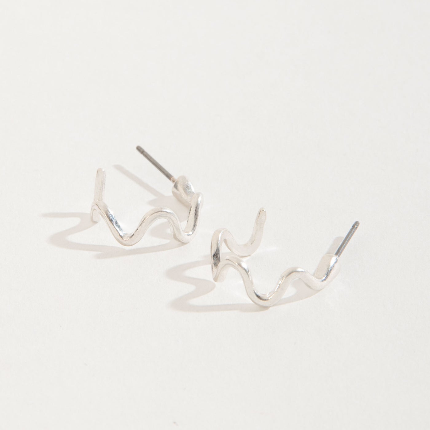 silver wiggle hoop stud earrings on a white background