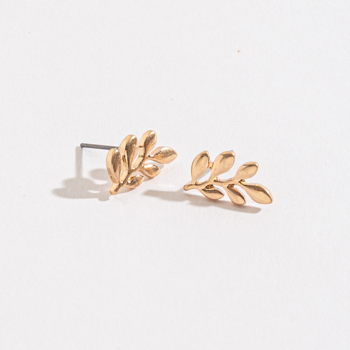 gold leaf stud earrings on a white background