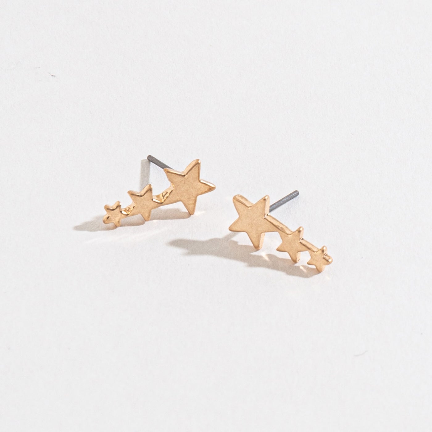 gold shooting star stud earrings on a white background