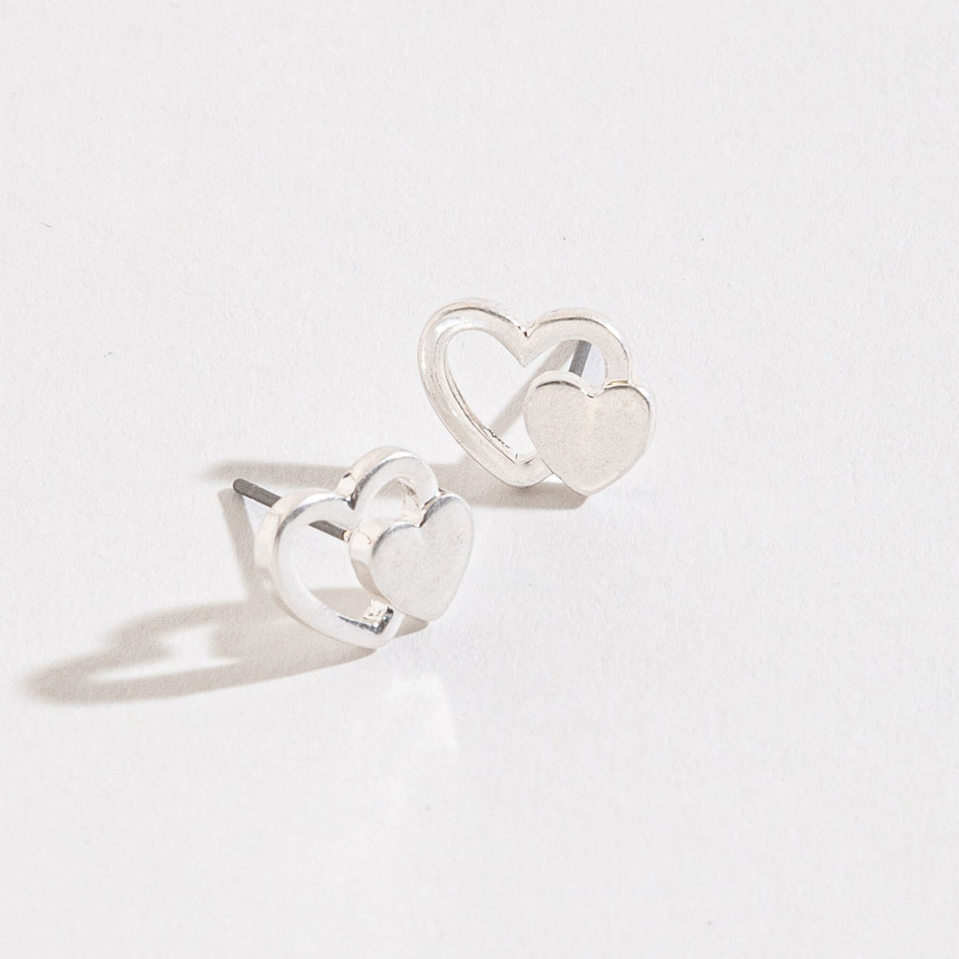 silver double heart stud earrings on a white background
