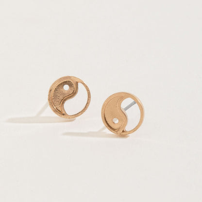 gold yin yang stud earrings on a white background