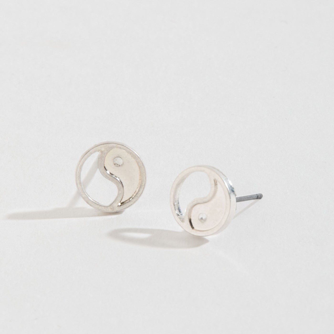 silver yin yang stud earrings on a white background