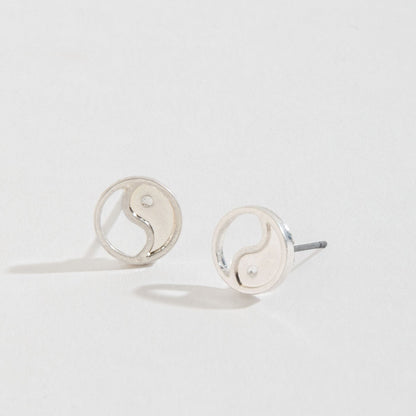 silver yin yang stud earrings on a white background