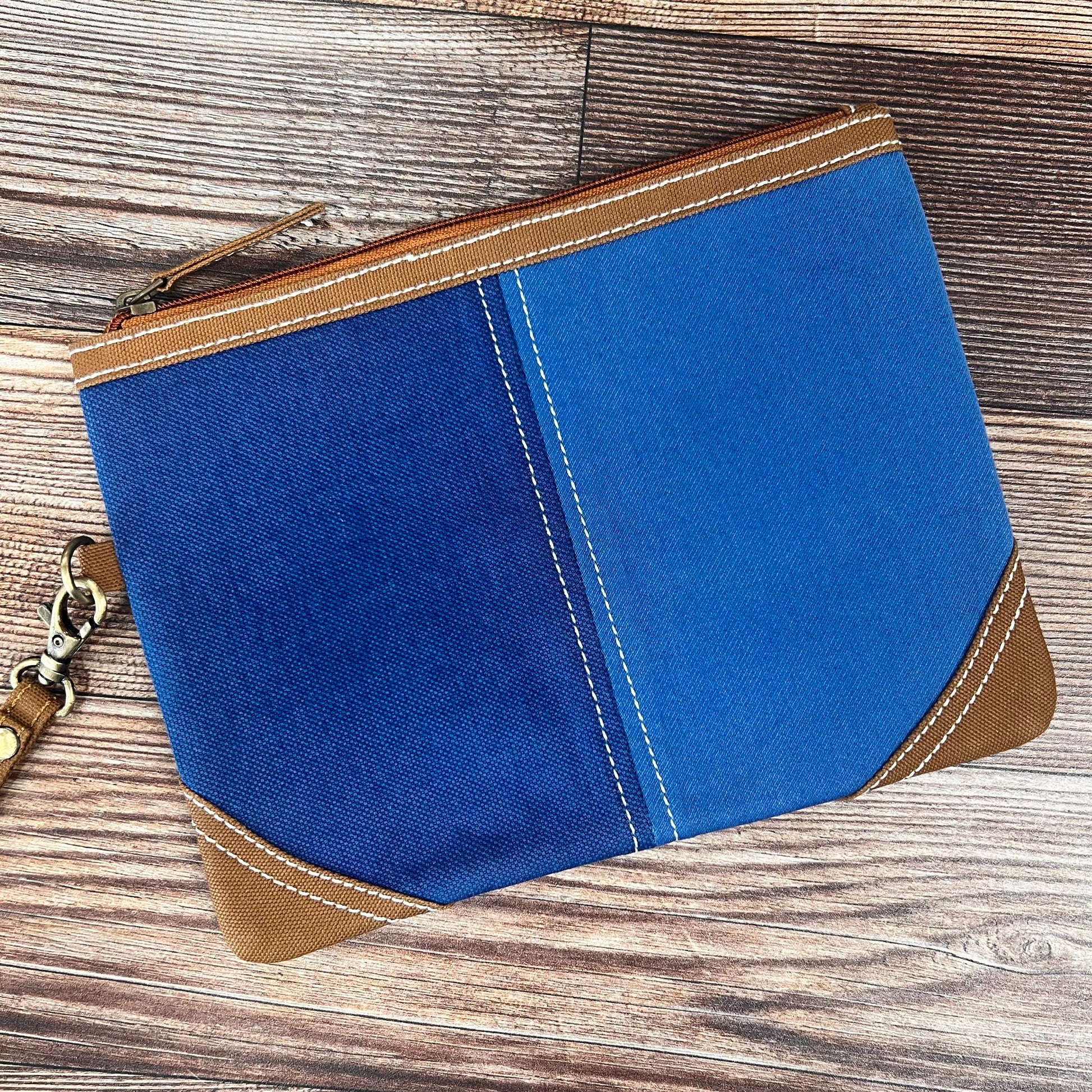 denim wristlet on a wood slat background.