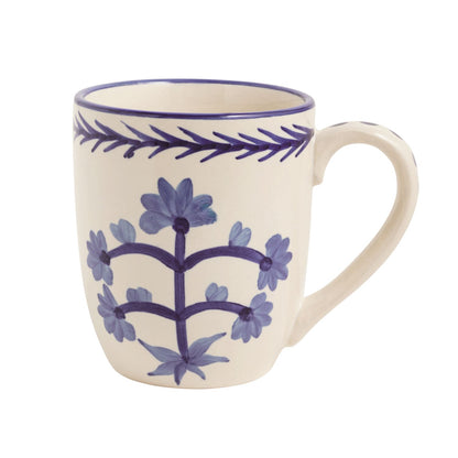 white mug with blue floral design and leaf pattern on rim