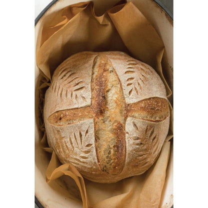 Loaf of bread with decorative crust on a beige paper-lined container