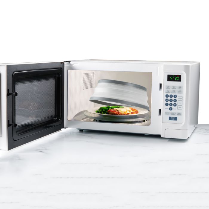 plate of food in a microwave with Collapsible Microwave Food Cover on it