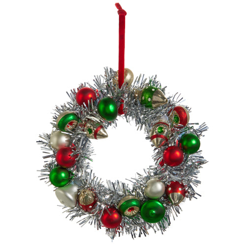 silver tinsel wreath with red green and white ornaments on it.