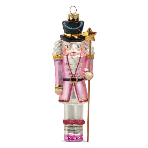 glass nutcracker ornament wearing a pink uniform.