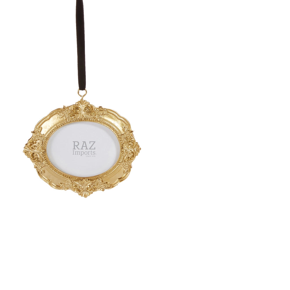 oval gilded gold frame ornament hanging on a white background by a black ribbon