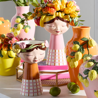 girl head ceramic vase with fruit in a decorated setting 