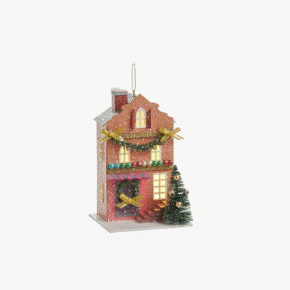coral colored house ornament decorated for christmas with lights in the  windows