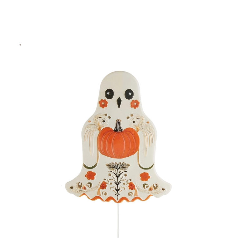 A decorative ghost-shaped yard stack with black eyes, orange floral accents, and holding an orange punpkin