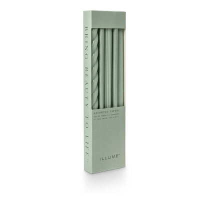 three assorted green taper candles in their packaging