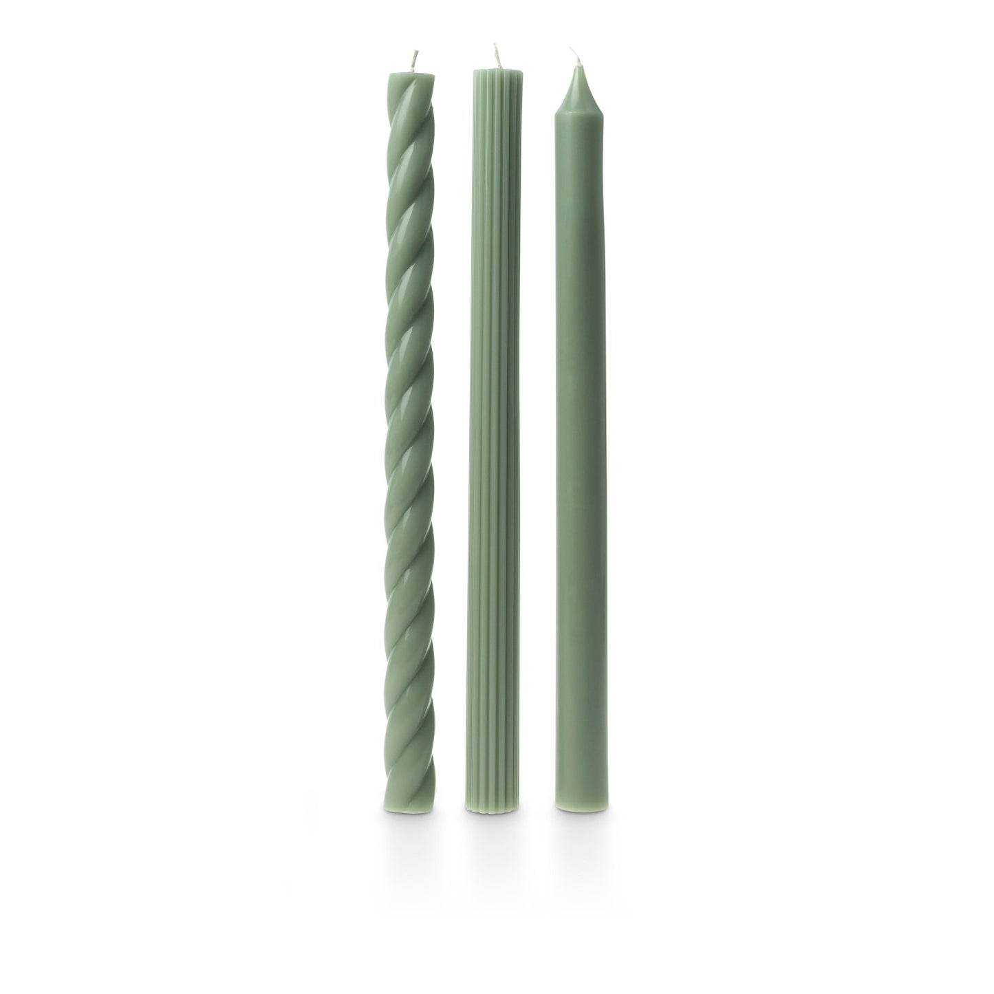 three assorted green taper candles on a white background