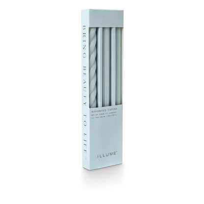 three assorted light blue taper candles in their packaging