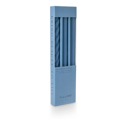 three assorted blue taper candles in their packaging