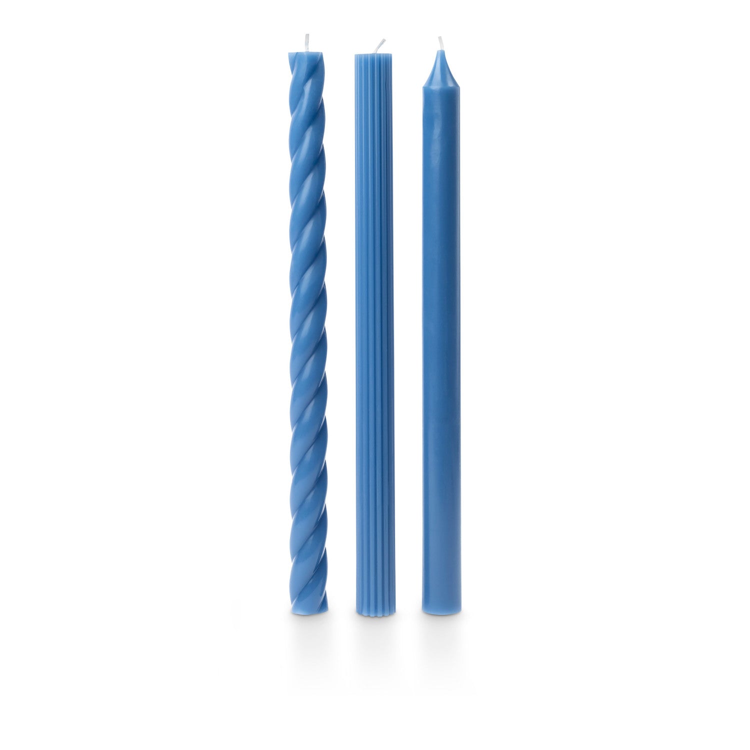 three assorted blue taper candles on a white background