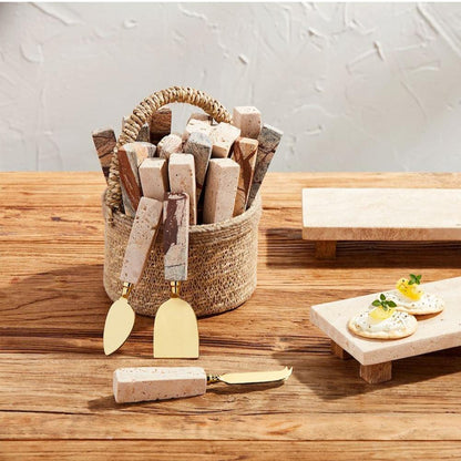 basket full of travertine cheese utensils set on a wooden table.